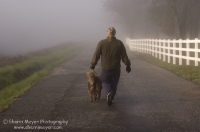 Man and dog walking, rural Auburn, California   Man walking his dog down a foggy country road, Auburn California