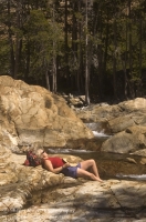 Canyon Creek, California Hiker relaxing on the rocks next to Canyon Creek, Tahoe National Forest, California