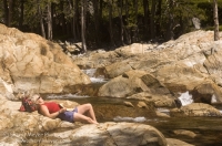 Canyon Creek, California Hiker relaxing on the rocks next to Canyon Creek, Tahoe National Forest, California
