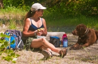 DH-0589 Woman eating her picnic lunch, while her dog politely begs for a bite, North Fork of the American River, Weimar, California.