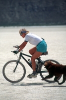 Mountain Biking in the Black Rock Desert, Nevada  Woman mountain biking with her dog, on the playa, in the Black Rock Desert, Nevada