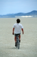 Mountain in the Black Rock Desert, Nevada  Man cruising across the playa on his mountain bike, in the Black Rock Desert, Nevada