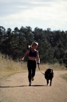 Trail running in Palmer Lake, Colorado Woman trail running with her dog, Palmer Lake, Colorado