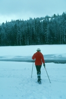 Woman snowshoeing, Eagle Mountain Resort, California Woman snowshoeing through a meadow at Eagle Mountain Resort, Northern California