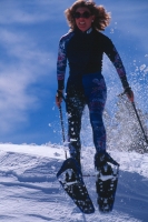 Woman showshoeing, Eagle Mountain Resort, California  Woman jumping off a ledge in snowshoes, Eagle Mountain Resort, California