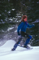 Woman showshoeing, Castle Peak, California Woman running in snowshoes at Castle Peak, Northern California
