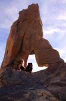 Alabama Hills Woman and dog sitting in an arch, Alabama Hills, Lone Pine, California