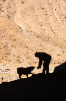 DT-CA-07-08 Man and his dog exploring a cave in Cottonwood Canyon, Death Valley National Park, California
