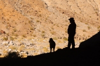 Exploring Cottonwood Canyon  Man and his dog exploring a cave in Cottonwood Canyon, Death Valley National Park, California