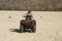 Cabo San Lucas, Mexico Woman riding a Quad in the arroyo near Migrino, Baja California, Mexico