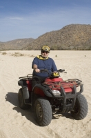 Cabo San Lucas, Mexico Man riding a Quad in the arroyo near Migrino, Baja California, Mexico