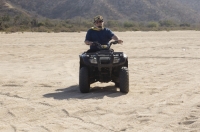 Cabo San Lucas, Mexico Man riding a Quad in the arroyo near Migrino, Baja California, Mexico