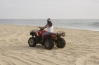 Cabo San Lucas, Mexico Woman riding a Quad on the playa near Migrino, Baja California, Mexico