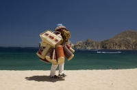 Cabo San Lucas, Mexico Beach vendor walking on the beach (playa), Cabo San Lucas, Baja California, Mexico 