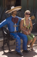 Cabo San Lucas, Mexico Tourist sitting with a statue of a Mexican Cowboy (Vaquero) at the Marina, Cabo San Lucas, Baja California, Mexico